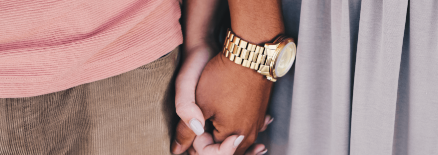 A man and woman stand side by side holding hands (only their hands are visible); photo via Lareised Leneseur/Unsplash.